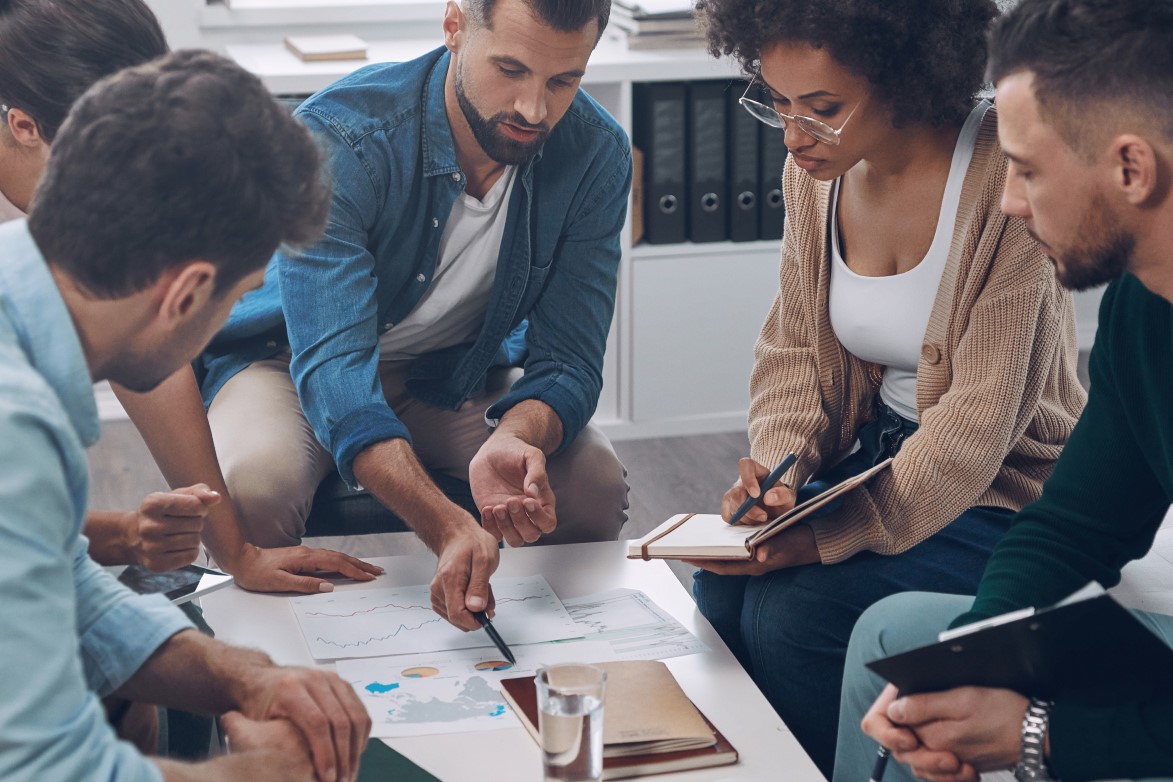 Top view of confident business team analyzing data while sitting in the office together