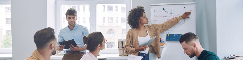 Group of confident young people in smart casual wear discussing business while having meeting in office