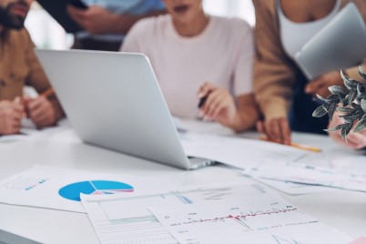 Close-up of modern people in smart casual analyzing data while having meeting in office