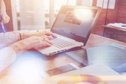 Close-up view of interior designer workspace with laptop, graphic tablet, phone and color palette on desk