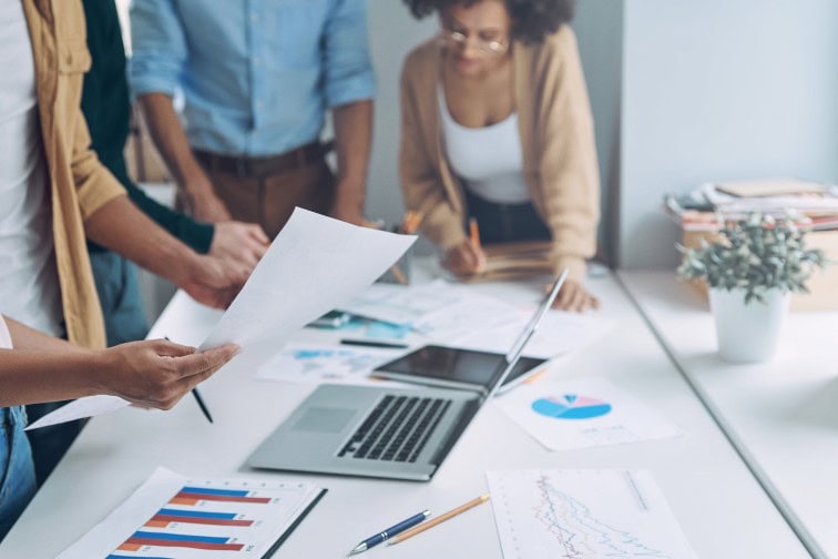 Close-up of modern people in smart casual analyzing data while having meeting in office