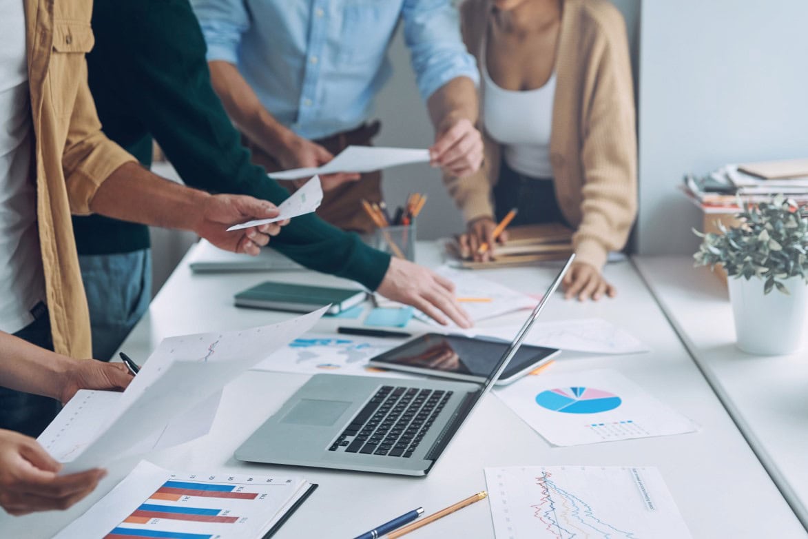 Close-up of modern people in smart casual analyzing data while having meeting in office