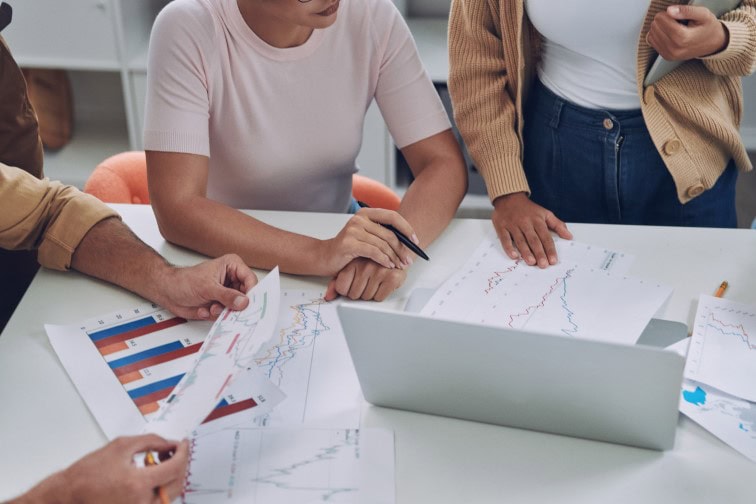 Close-up top view of modern young people in smart casual analyzing data while having meeting in office