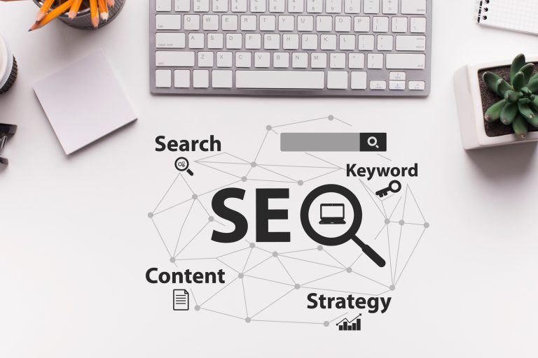 Image of a desk with a keyboard, stationary, and a plant, featuring a visual representation of SEO with connected terms like Search, Keyword, Content, and Strategy.